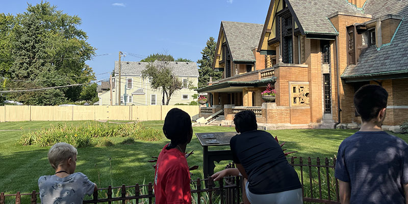 On a neighborhood walking tour, campers turn their attention to the Nathan Moore House and learn about the building’s restoration history.