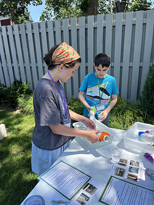Two campers study the significance of water in urban planning by creating water transportation models.