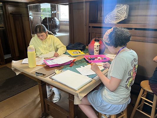 Two campers plan the floorplans for their models in Wright’s Drafting Room.
