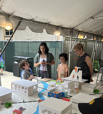 Two campers chat with staff about their completed community, Mapleville.