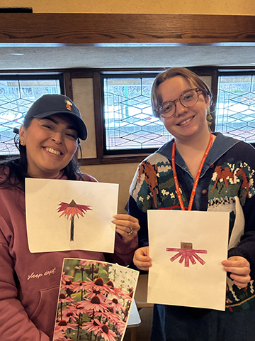 FLWT Educator Josie pairs up with an educator to show off their abstract drawings of cone flowers during a hands-on activity.
