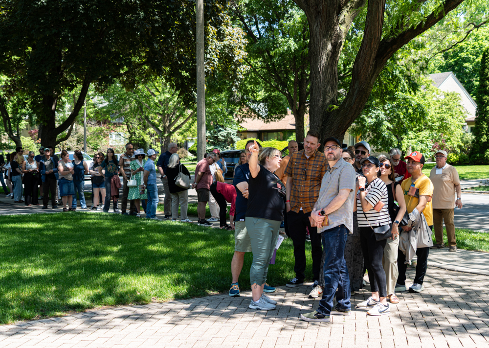 A house volunteer shares information as guests wait in line